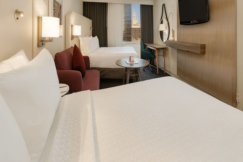 Settle into plush beds with a skyline view beyond.