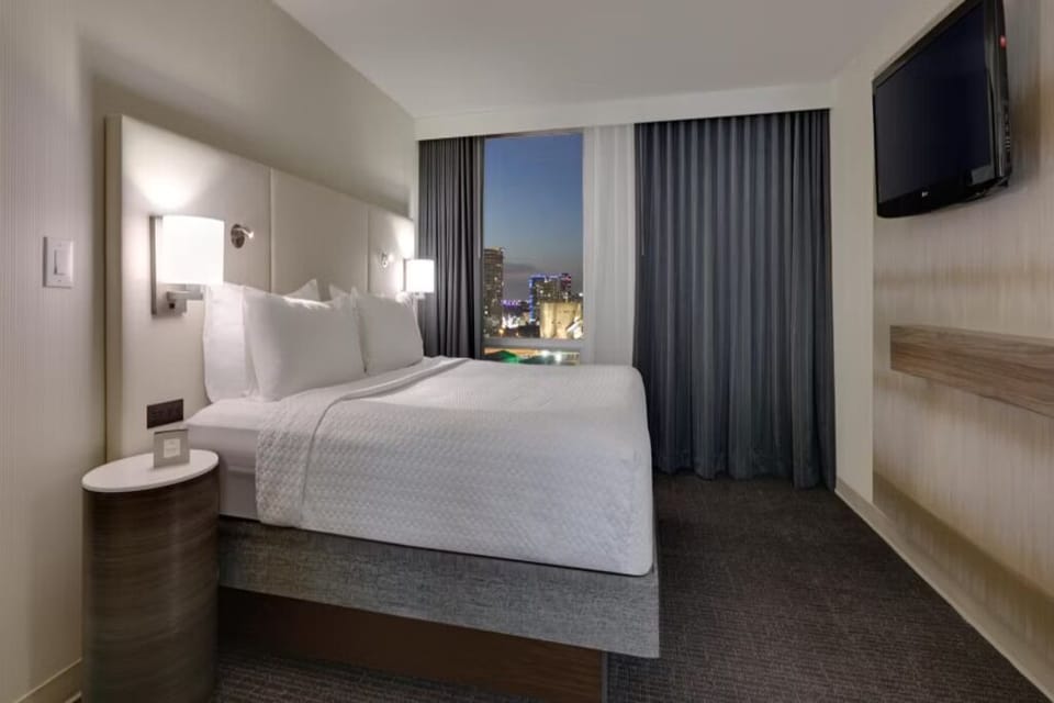 Soak in the nighttime skyline from your inviting bed.