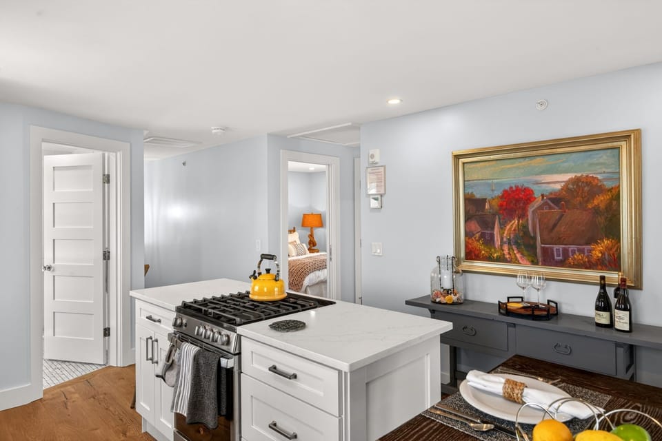 Whip up your morning coffee in a bright, fully-equipped kitchen with sleek counters, gas range, and charming art that captures the coastal spirit of your getaway.