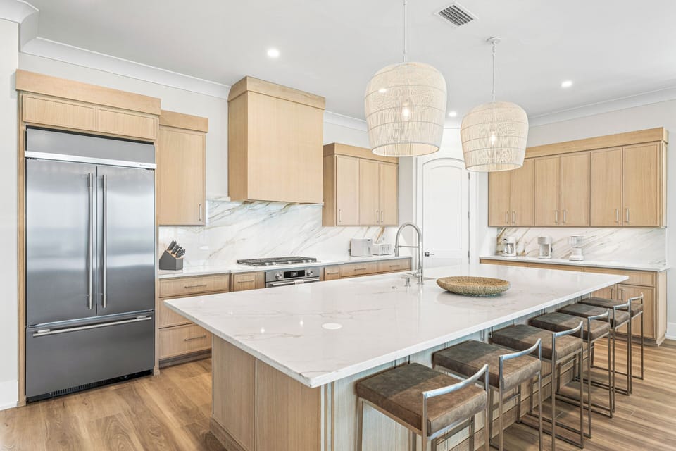Your chef's kitchen awaits with sleek marble countertops, stainless steel appliances, and a spacious island perfect for morning coffee or evening wine with friends.