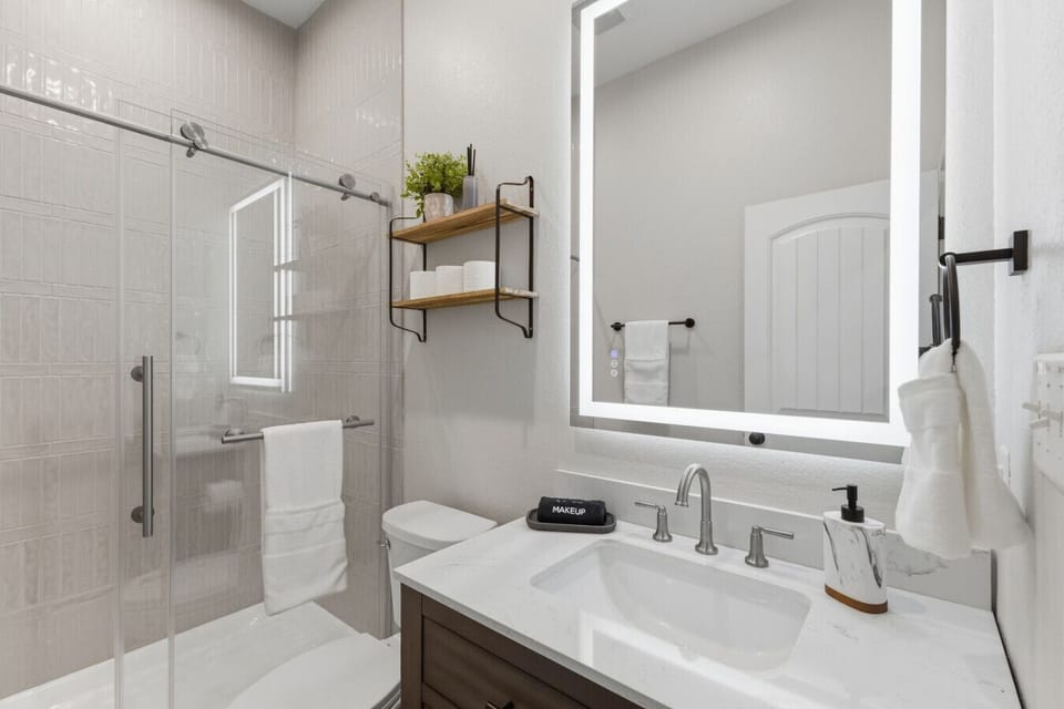 Bedroom 1 features a private ensuite bathroom equipped with essentials like bath towels, toilet paper, and a hair dryer.