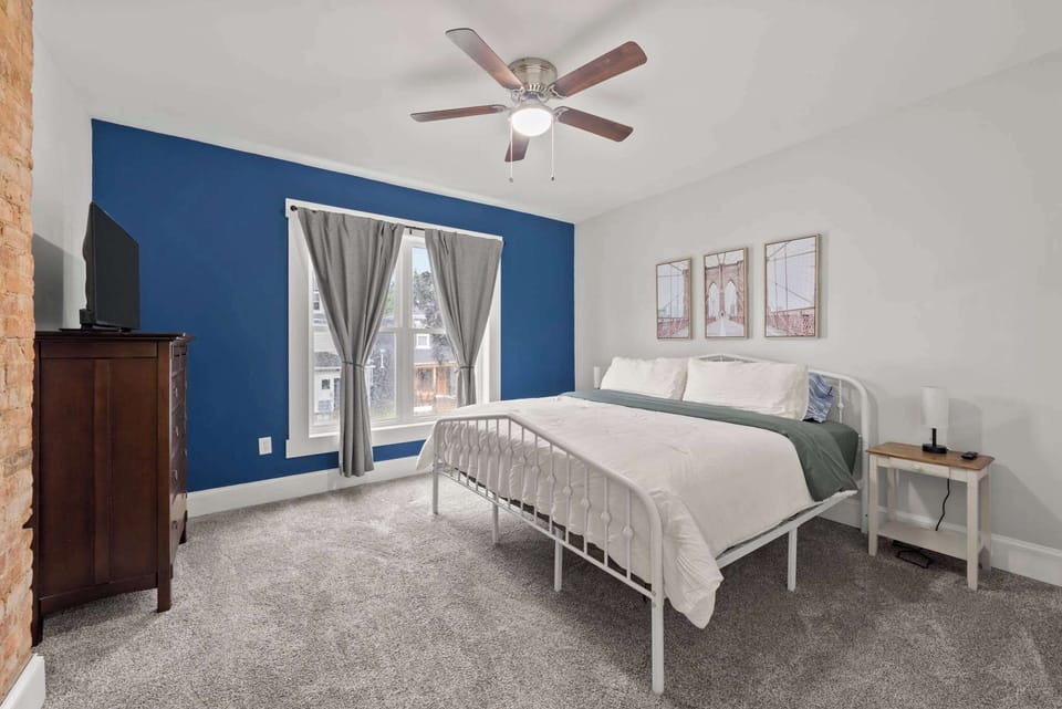Rest easy in the moody blue bedroom w/ classic dresser & mirror.