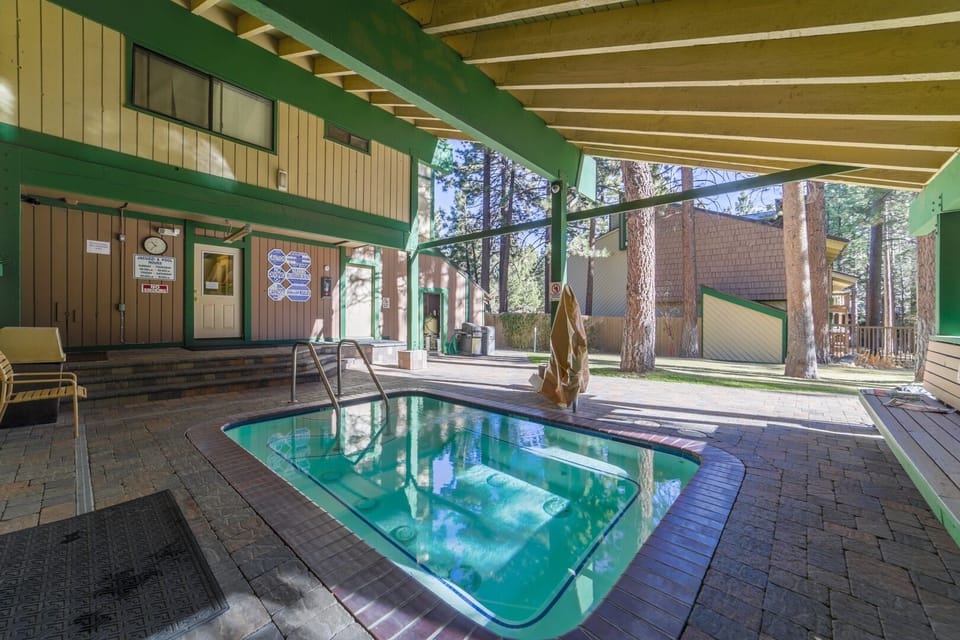 Covered outdoor hot tub surrounded by pines for year-round relaxation