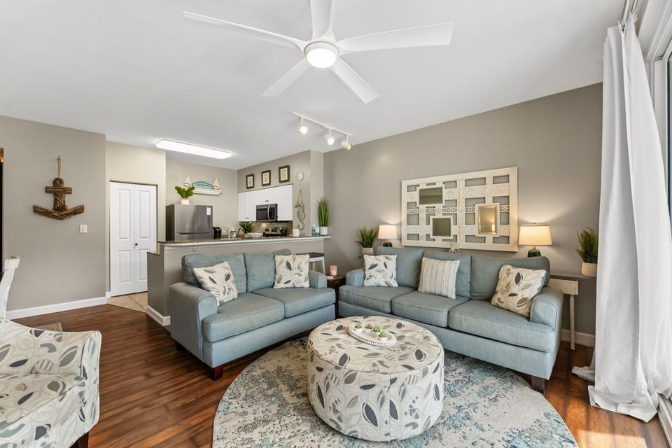 Cozy coastal living room with plush seating, an open view into the kitchen, and a pull-out sofa for additional sleeping space.