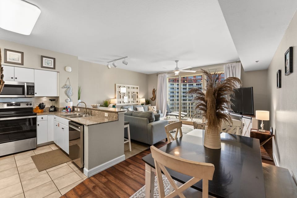 Open-concept kitchen, dining, and living area with coastal décor, comfortable seating, and plenty of space to relax after the pool or beach.
