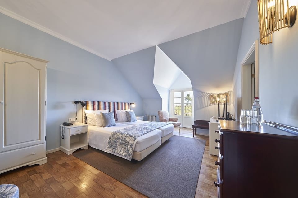 Unwind in a spacious, airy bedroom with cozy seating.