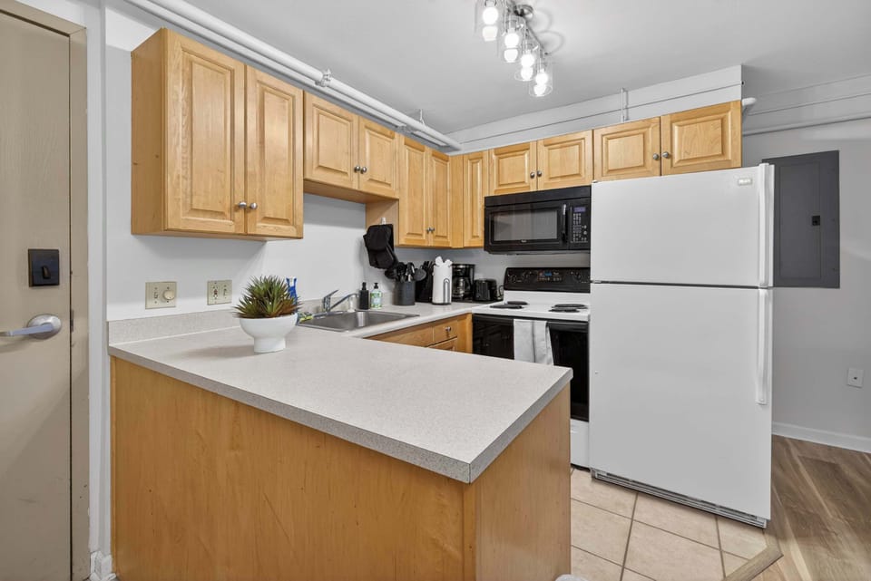 Bright kitchen w/ generous cabinetry, sleek appliances & ample prep space