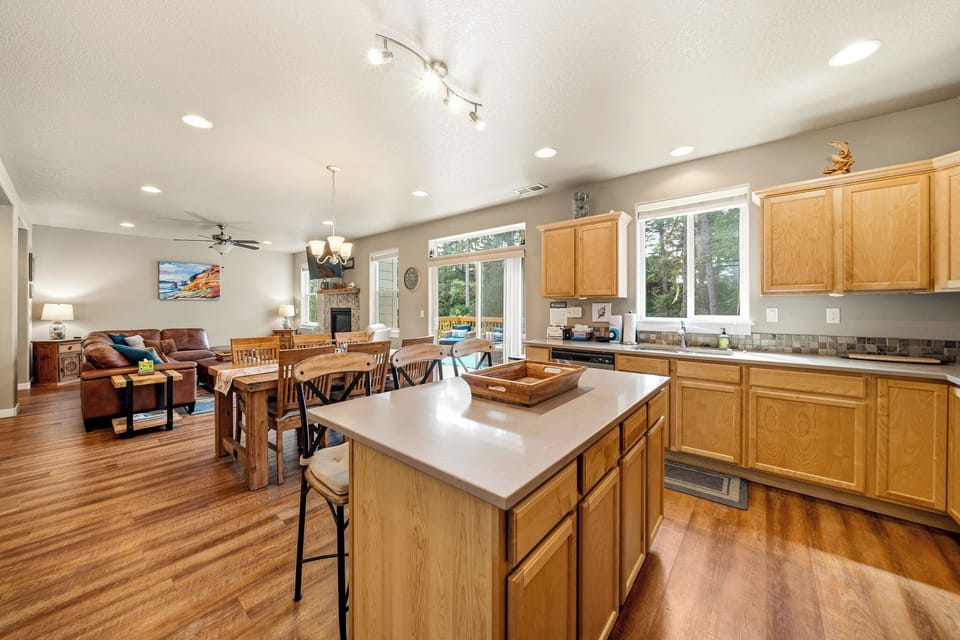 Gather in this bright, open-concept space where warm wood tones, a cozy fireplace, and natural light create the perfect setting for memorable meals and relaxed evenings.