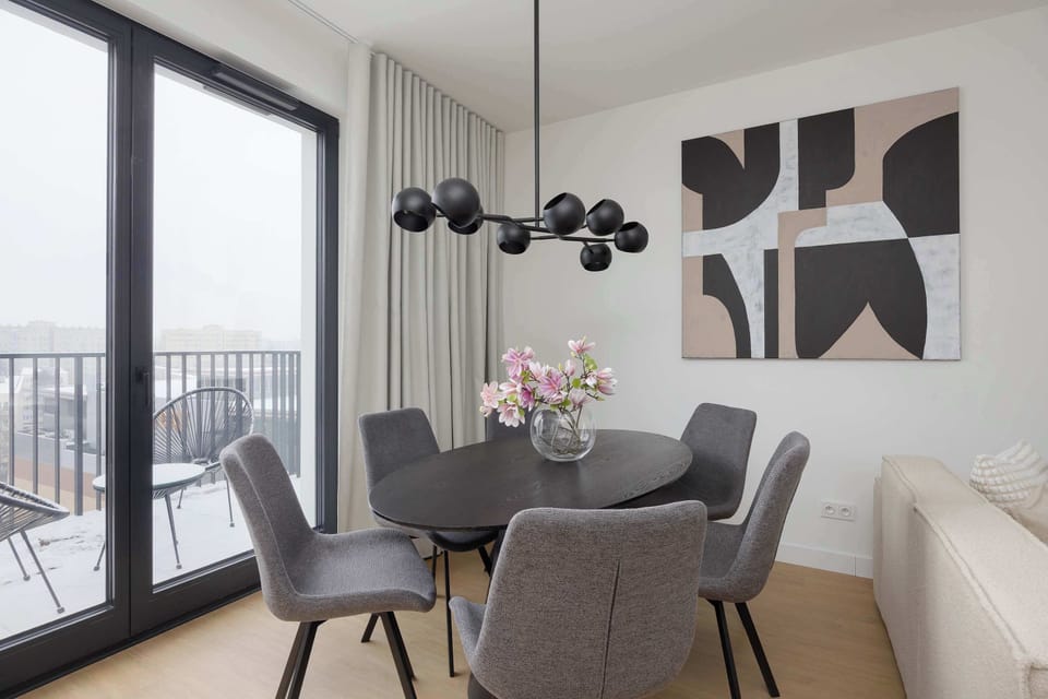 Sophisticated dining area with designer lighting, panoramic windows, and refined modern furnishings.