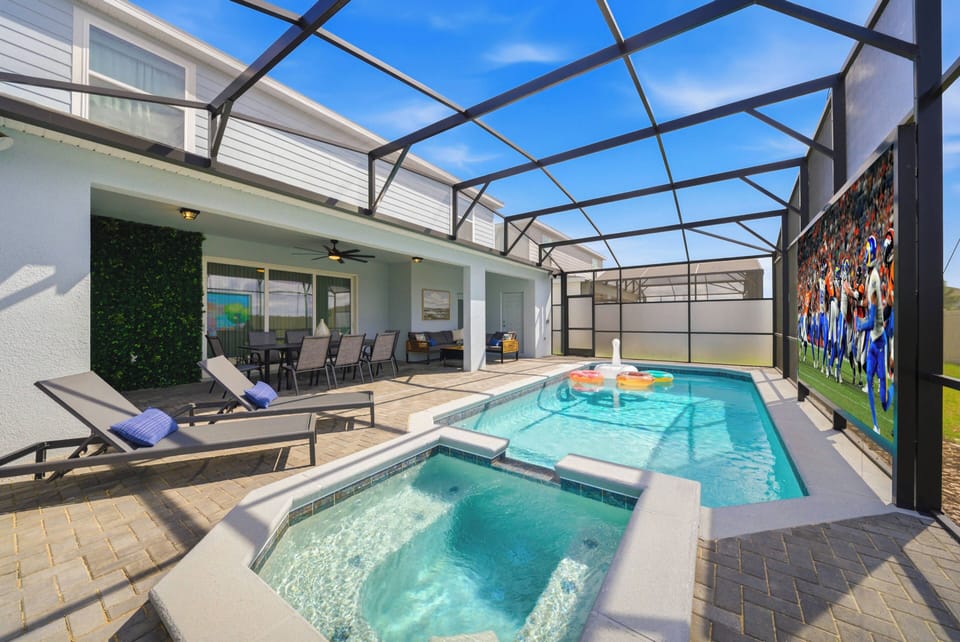 Step outside to enjoy a beautiful enclosed pool area with a sparkling blue pool and bubbling spa, ideal for relaxation. Comfortable lounge chairs invite you to soak up the sun amid vibrant decor that adds a splash of fun.