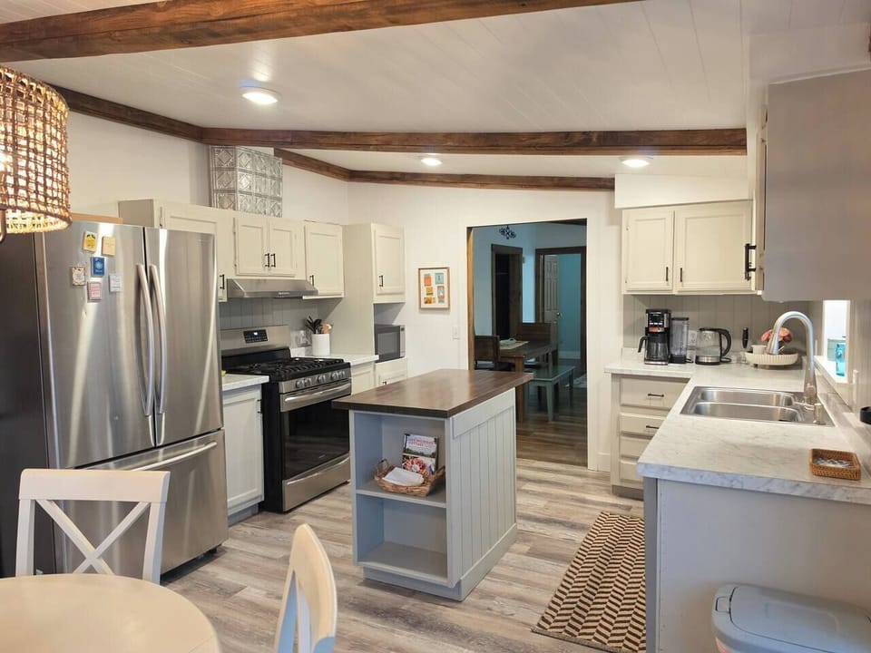 A cozy, fully stocked kitchen a new dishwasher, and a central prep island and lake views from every window.