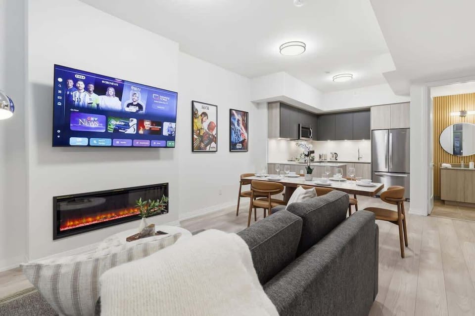 Open-concept living and dining area with Smart TV, fireplace, and modern kitchen