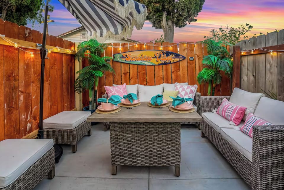 Patio lounge seating beneath an umbrella and string lights.