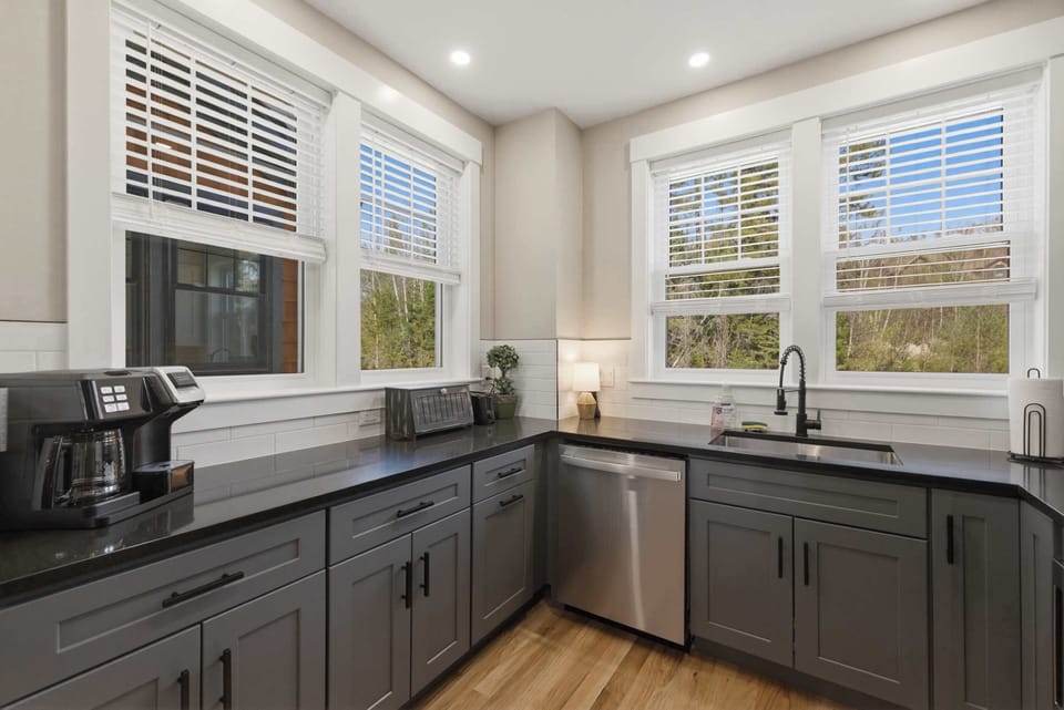The kitchen sink area with dishwasher, coffee maker, and plenty of counter space to keep things organized during a busy morning.