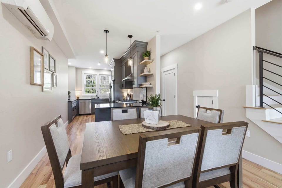 The dining area sits at the center of the main level, with the kitchen behind and the living room just beyond — the whole floor connects naturally for groups.