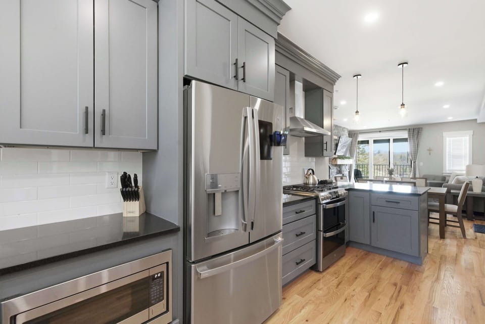 French-door refrigerator with water and ice, built-in microwave, and dark countertops — everything within reach for a full group cook.