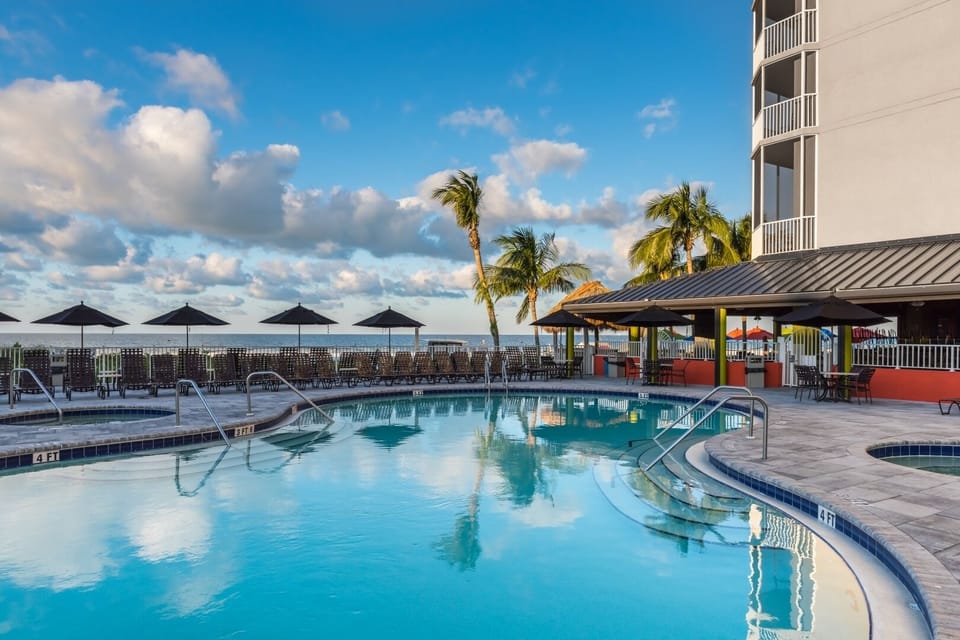 Linger in calm blue waters as palms sway nearby.