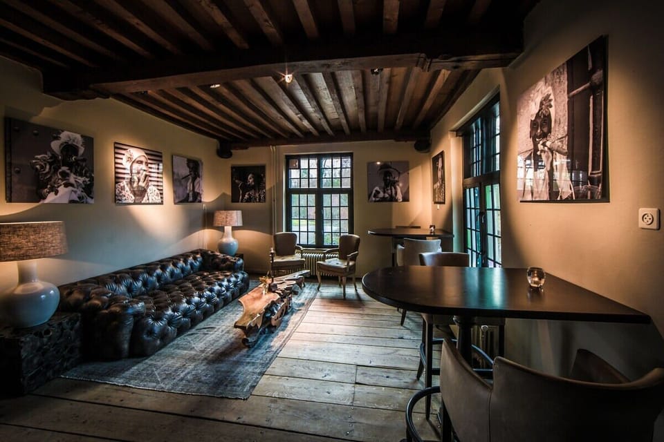 Unwind on the tufted sofa beneath warm, rustic beams