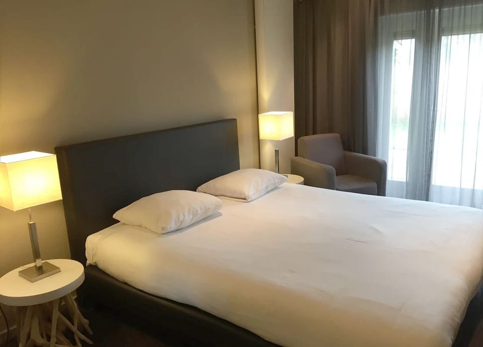 Unwind in crisp linens beside soft lamps and daylight.