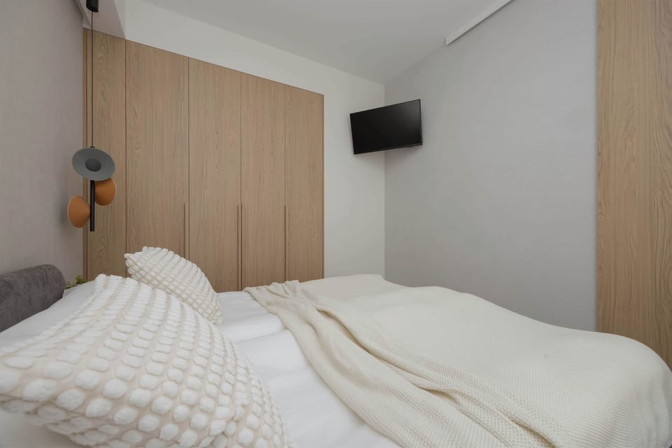 A close-up of a bed with textured pillows and a wooden headboard.