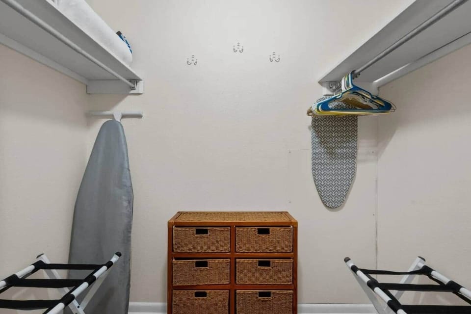 Walk in closet with 2 luggage racks. 