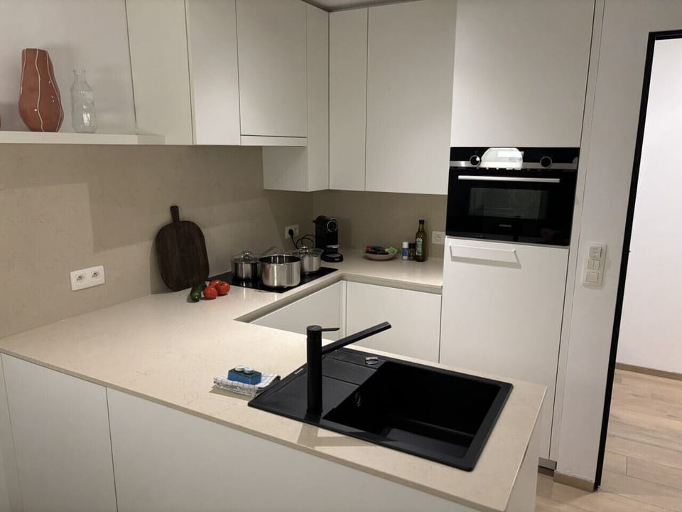 Strakke, moderne keuken met alle comfort om makkelijk te koken: van inductievuur tot oven en werkruimte.
