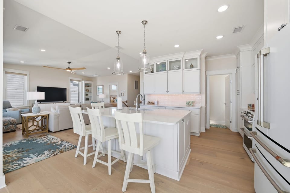 Modern Kitchen w/  Refrigerator, Built-In Microwave, Stove, Sink,  Oven, Dishwasher, Cooking Utensils, and Island Seating