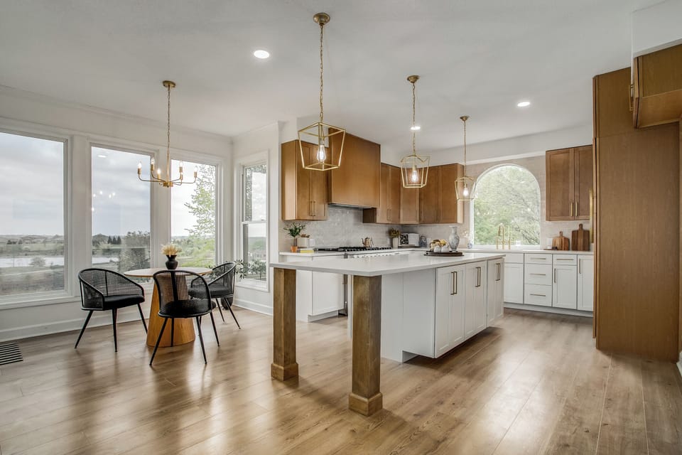 Bright chef’s kitchen with oversized island and elegant lighting.