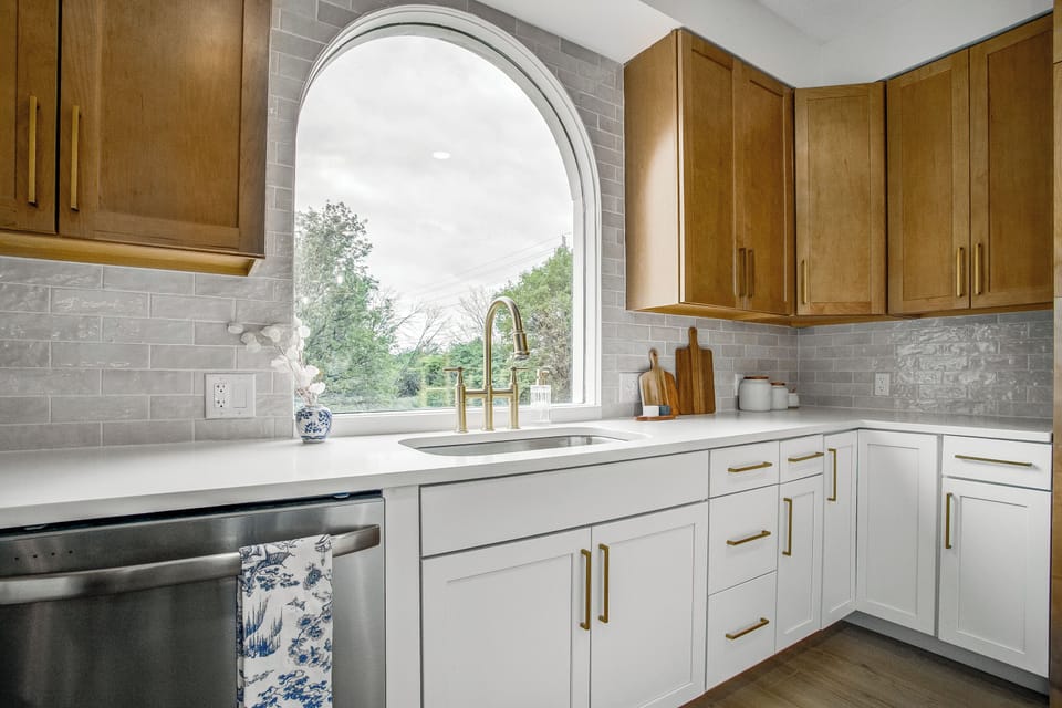 Kitchen sink view with arched windows and natural light.