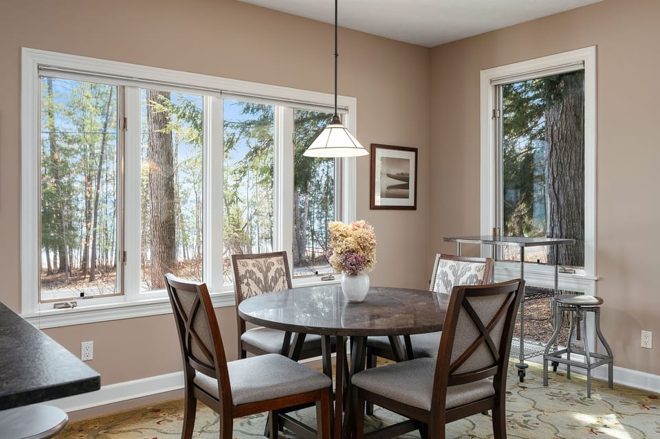 Bright dining area surrounded by nature and water edge views. 
