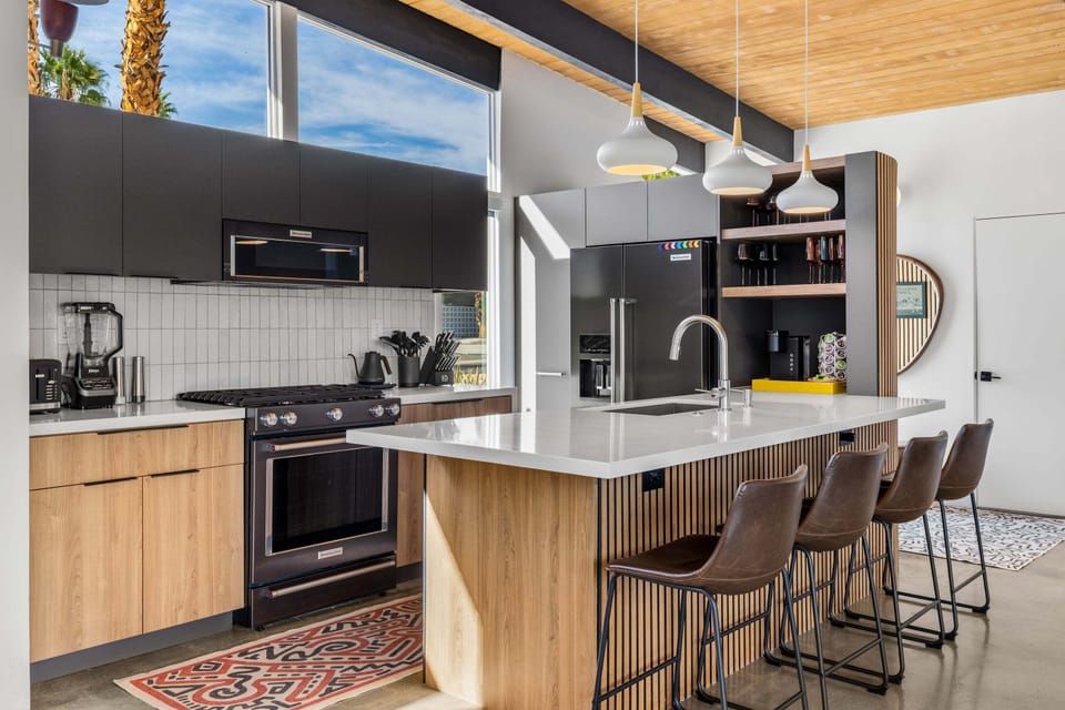 Your modern kitchen features sleek appliances, spacious island seating, and warm wood accents creating the perfect space for cooking and gathering.