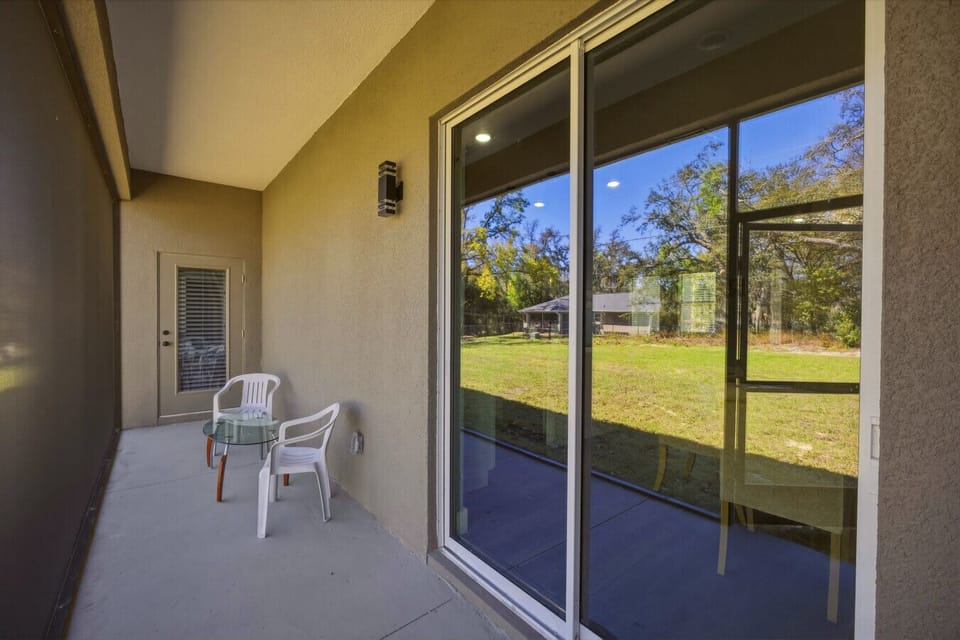 🌿 Relaxing patio just steps from the living area, framed by glass doors that create a bright, seamless indoor-outdoor flow ☀️🏡