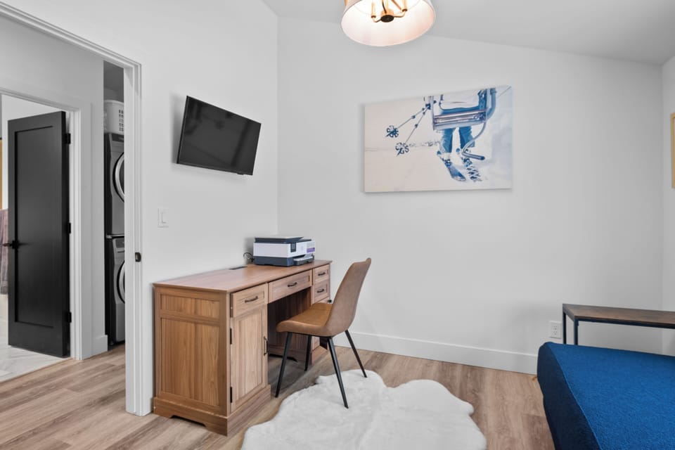 Stylish WFH nook: desk, printer, TV, with laundry next door