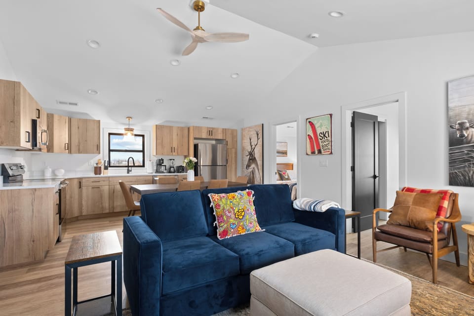 Stylish open living with modern kitchen, vaulted ceilings, and cozy seating.