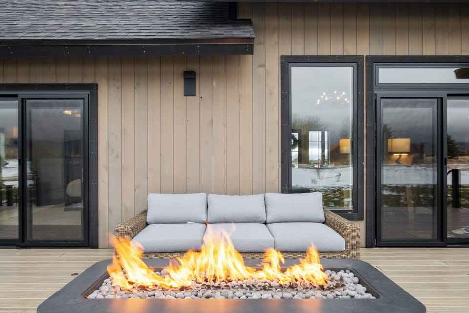Cozy patio with modern fire pit and cushioned sofa—perfect for evening lounging.