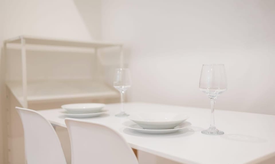 Modern dining table with seating and neatly arranged tableware, creating a welcoming setting for meals.