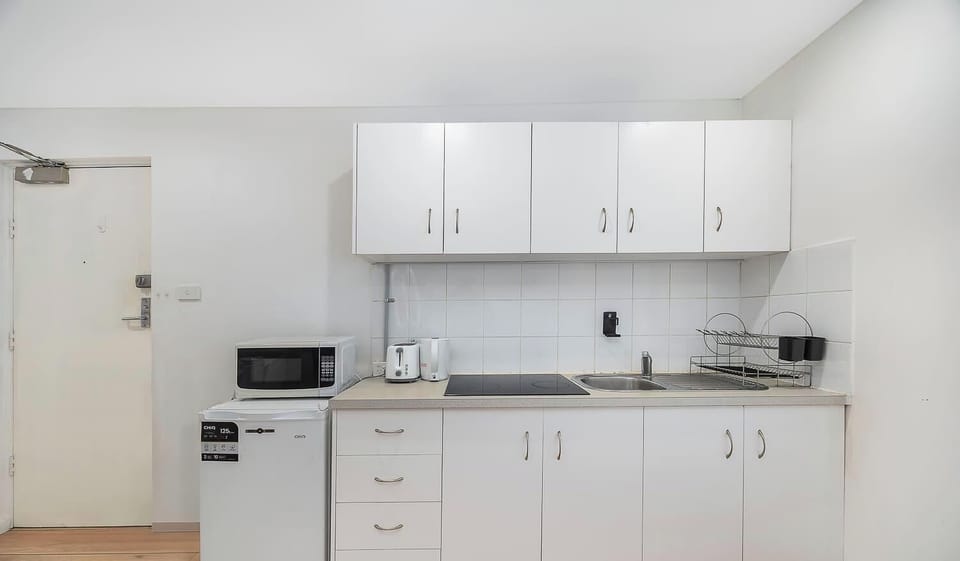 
Neat and functional kitchenette with ample cabinetry and essential appliances for convenient meal preparation.