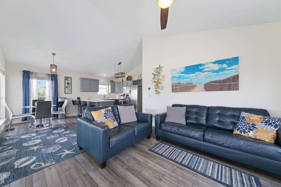 Gather in the open living room beneath vaulted ceilings with the kitchen just steps away