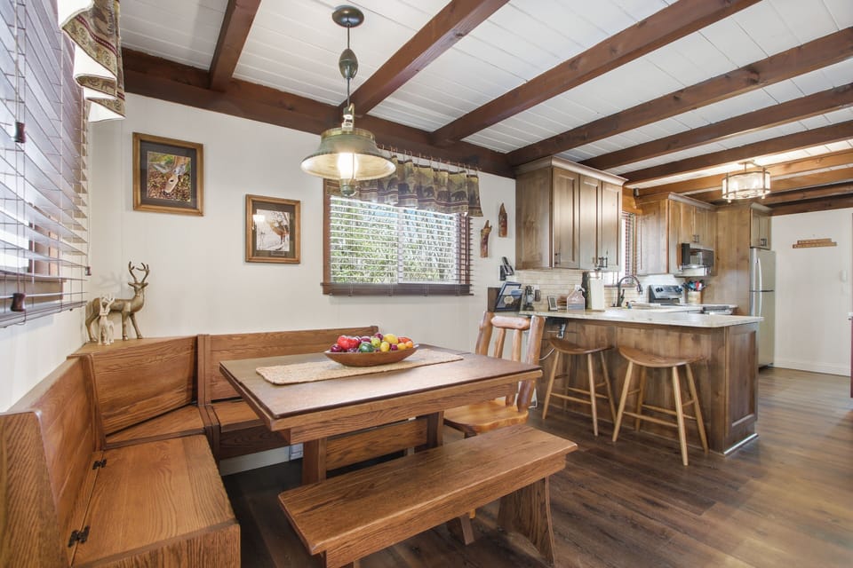 Cozy dining nook with bench seating, opening to the fully equipped kitchen