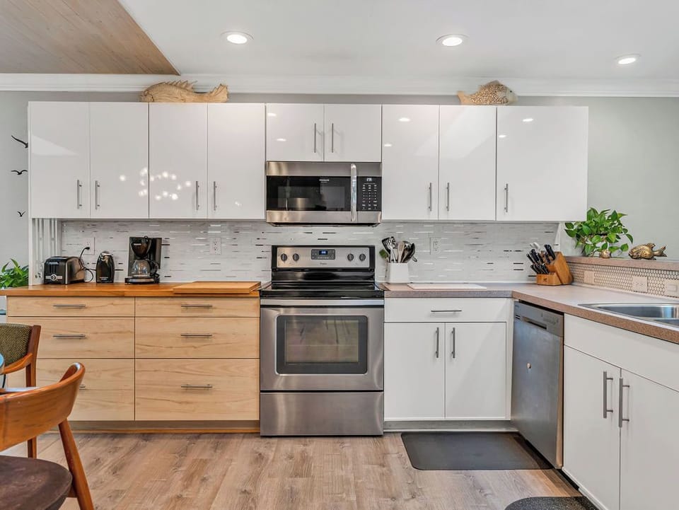 Spacious open kitchen! View of microwave, range, cabinets & dishwasher.