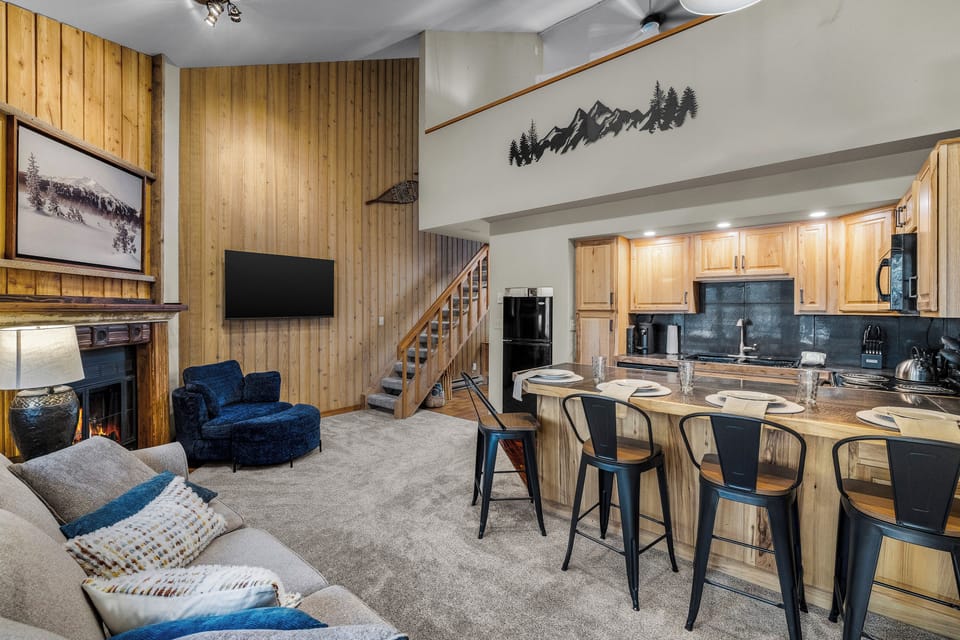 Settle into this inviting open-concept space where warm wood tones and mountain-inspired decor create your perfect alpine retreat. Gather around the kitchen island or relax by the fireplace after your day of adventure.