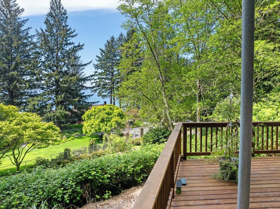 This property is nestled among lush evergreens and leafy trees, set in a peaceful neighborhood with expansive green lawns and abundant natural surroundings.