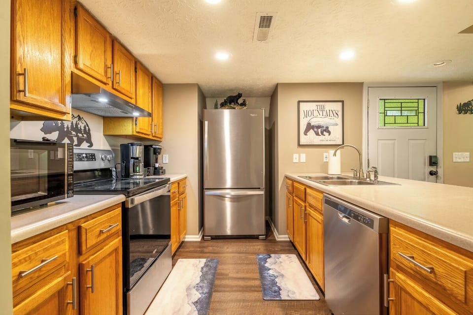 Your fully equipped kitchen awaits, complete with stainless steel appliances, warm wood cabinetry, and all the tools you need to prepare meals during your mountain escape.