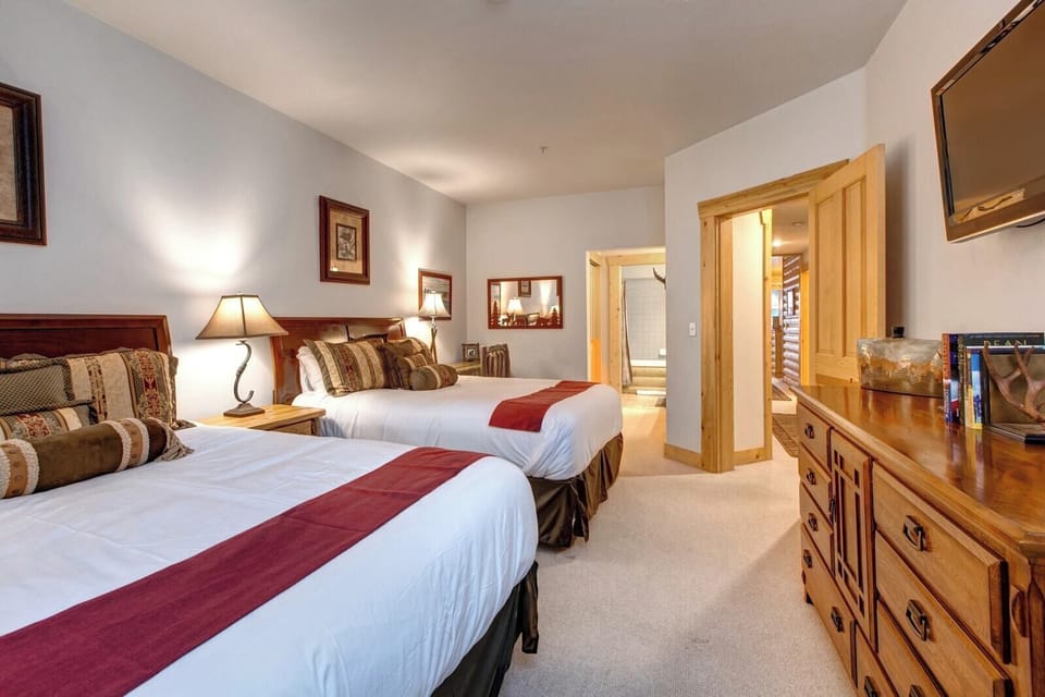 Spacious guest bedroom with two Queen beds and direct access to a full ensuite bath.
