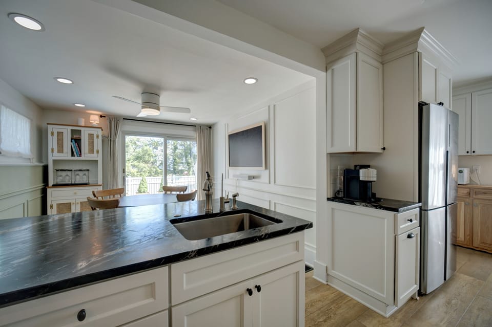 Kitchen includes Nespresso coffee maker w/ pods adjacent to the refrigerator.