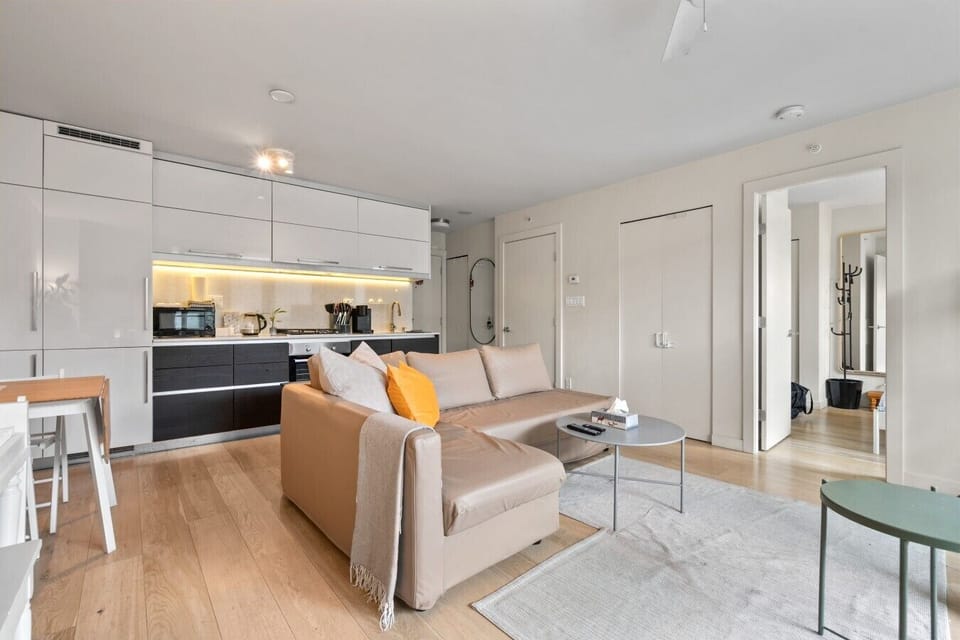 Living Room: Sunlit retreat with modern decor, inviting sofa, and a sleek kitchenette for fun meals!