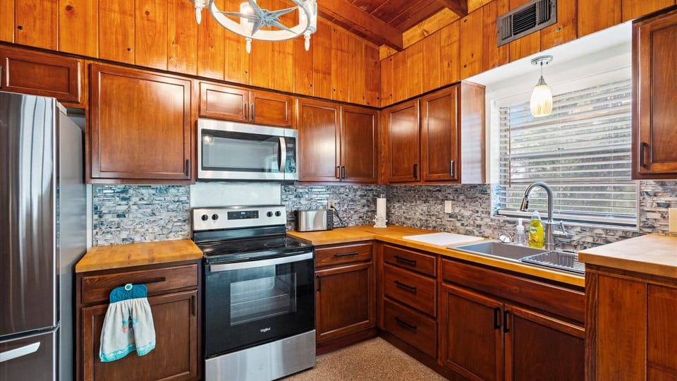 The rustic kitchen is well equipped with cooking essentials, coffee maker, oven, stove, full size refrigerator and freezer, microwave, and toaster.