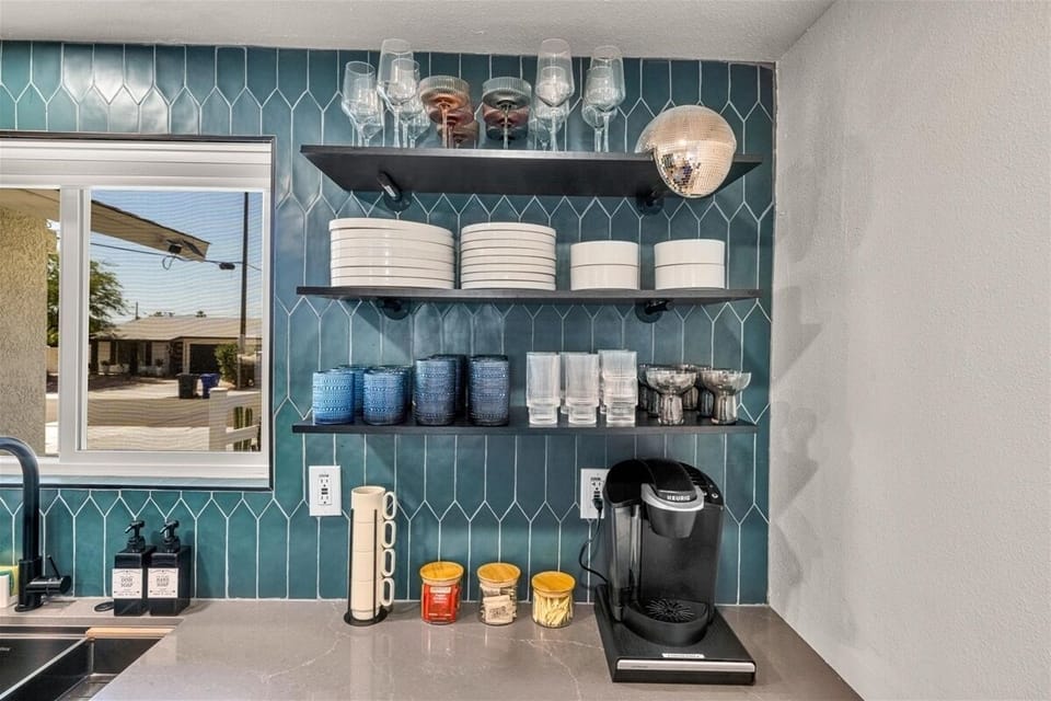 Coffee station with open shelving, glassware, and Keurig machine