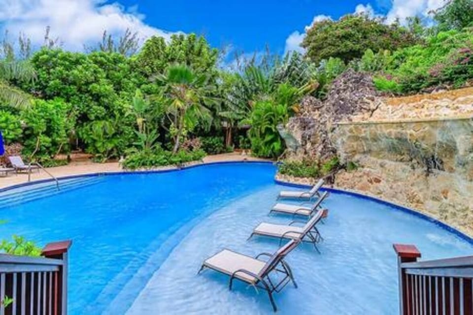 Shared swimming pool with sun loungers and a sun deck.