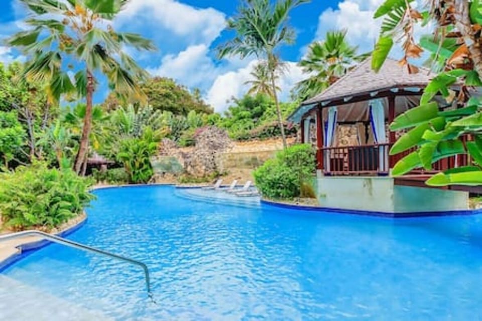 Shared swimming pool with sun loungers and a sun deck.
